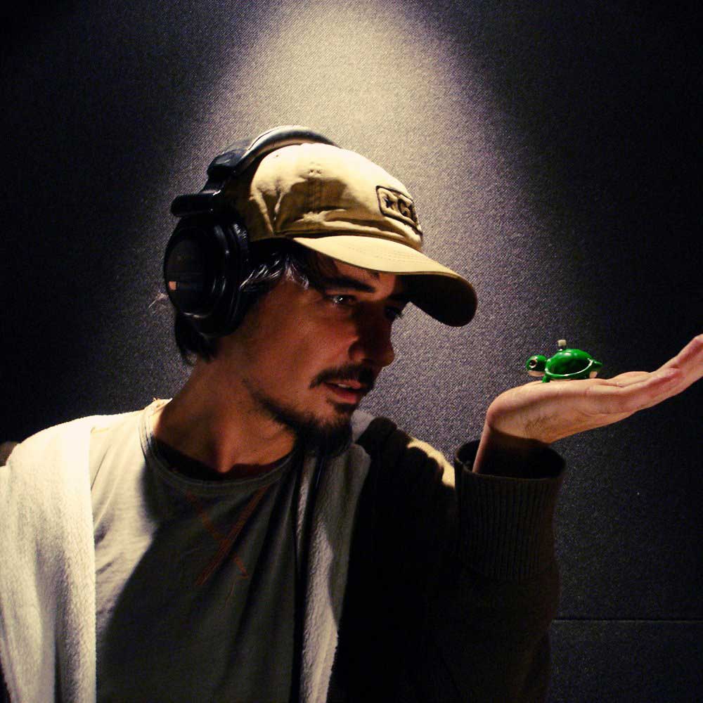 Amon Tobin holding a plastic wind up frog in hand