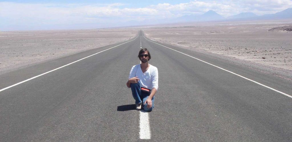 Ricardo Villalolbos kneeling on open road