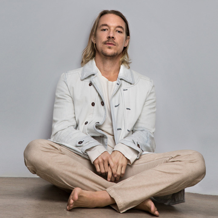 Diplo sitting on floor crosslegged and barefoot