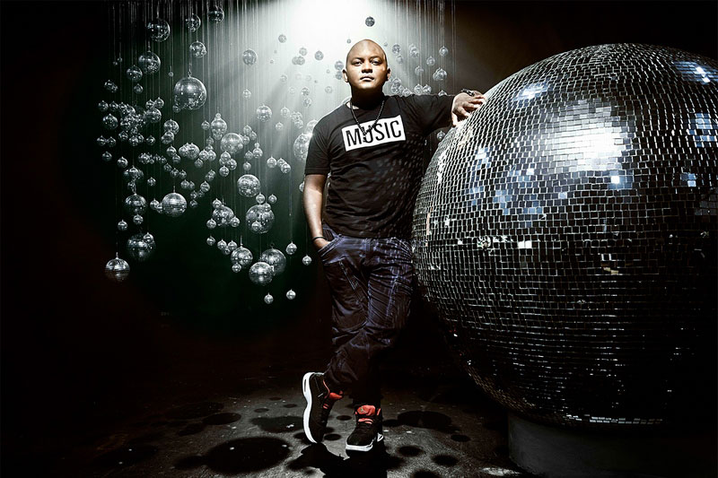 DJ Themba standing against giant gliterball