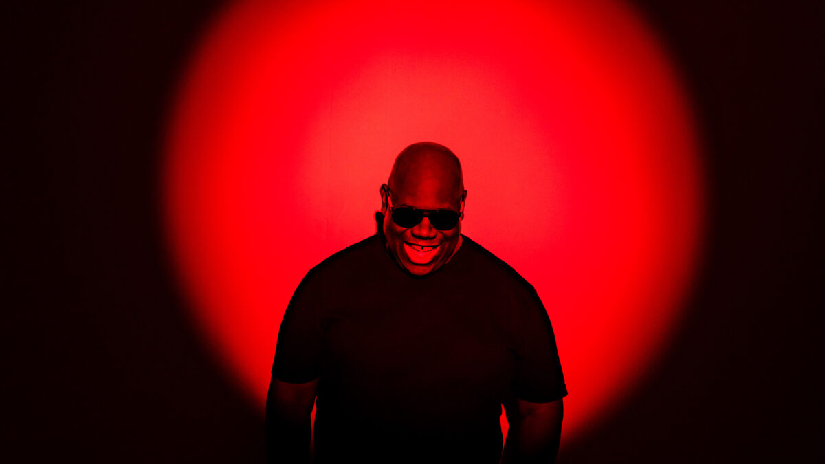 DJ Carl Cox smiling against red sunset effect background